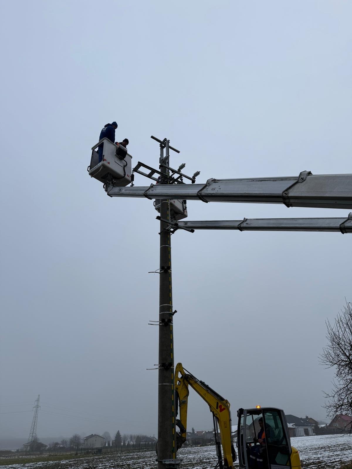 Montaż konstrukcji na słupie elektroenergetycznym z podnośników